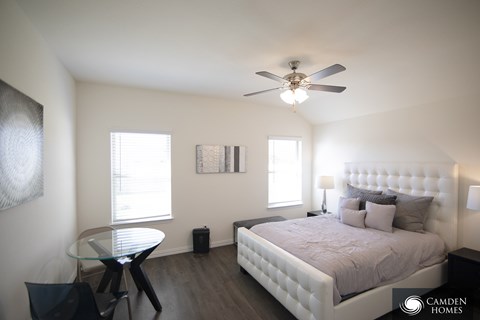 A Camden Homes bedroom with a bed, table, and chairs.