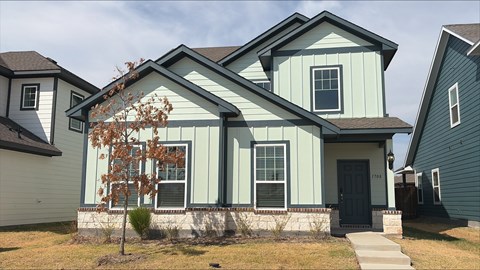 A house with a greenish exterior and a black door.