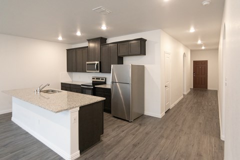A kitchen with a granite countertop and stainless steel appliances.
