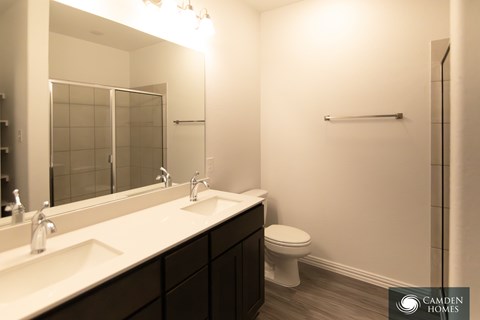 A bathroom with a toilet, sink, and mirror.