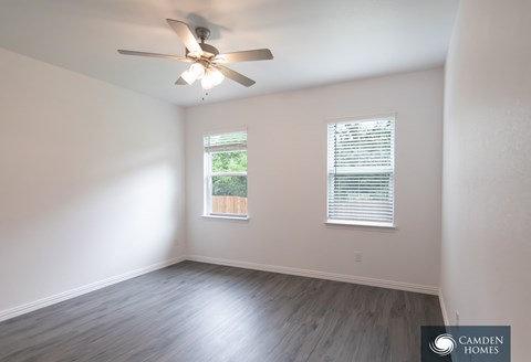 A Camden Homes branded empty room with a ceiling fan and a window with blinds.