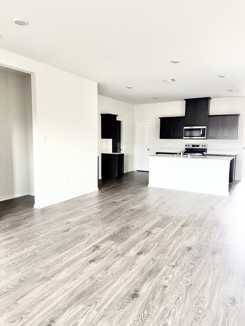 A modern kitchen with a white island and black countertops.