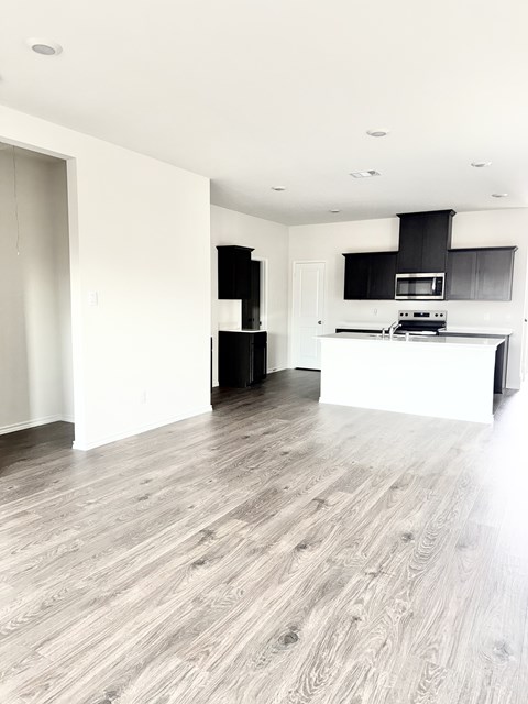 A modern kitchen with a white island and black countertops.