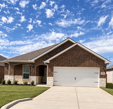A house with a white garage door and a brick facade.