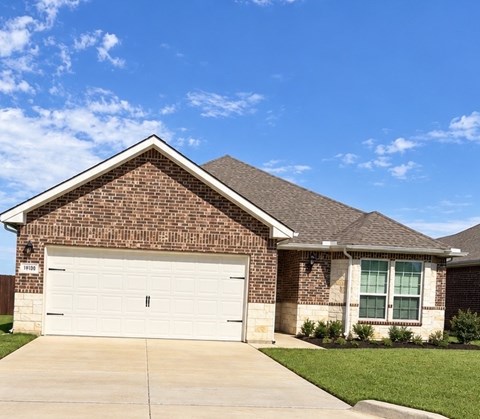 A house with a white garage door and a brick facade.