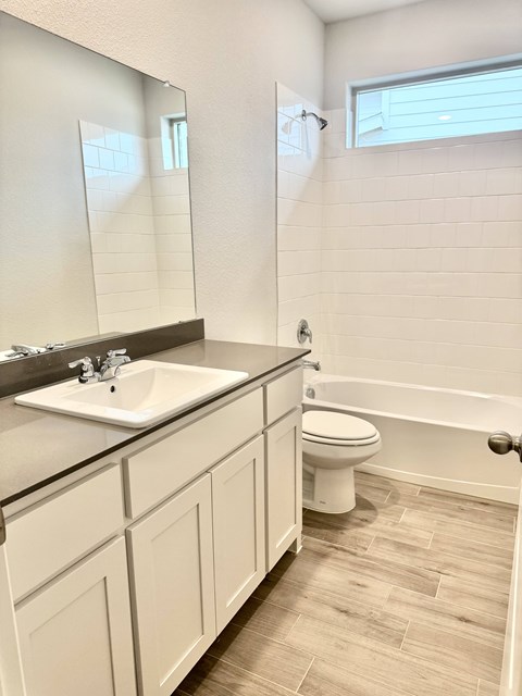 A white bathroom with a sink, toilet, and bathtub.