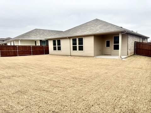 A house with a brown fence in front of it.