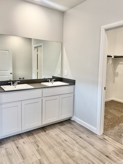 A bathroom with two sinks and a large mirror.