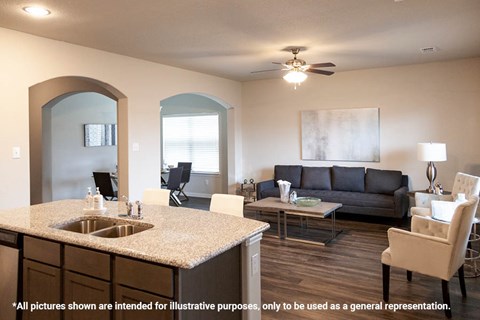 A modern kitchen with a large island and a living room with a couch.