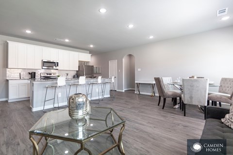 A modern kitchen with a glass table and chairs in a spacious room.