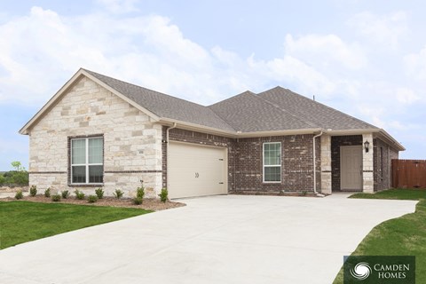 A house with a garage and a driveway in front of it.