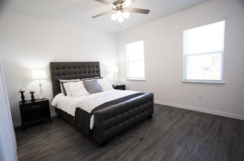 A bedroom with a large bed and a ceiling fan.