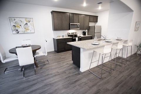 A kitchen with a table and chairs.