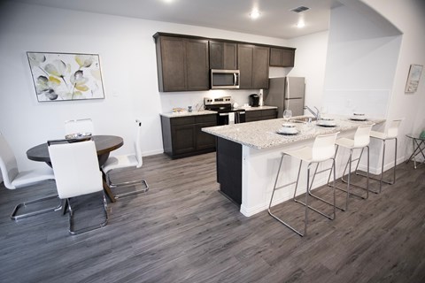 A kitchen with a table and chairs.