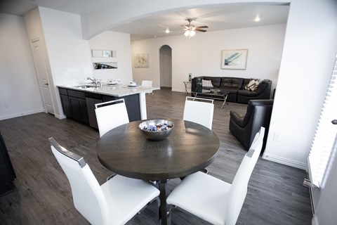 A modern dining room with a round table and white chairs.