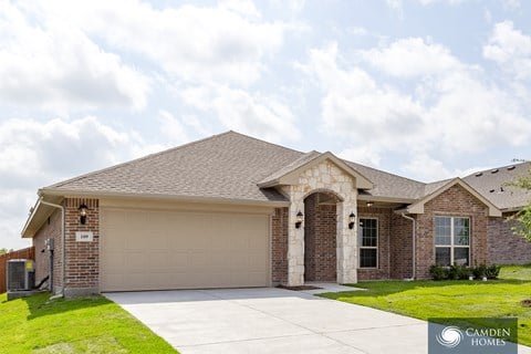 A house with a garage and a driveway in front of it.