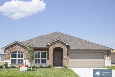 A house with a sold sign in front of it.