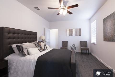 A bedroom with a large bed and a ceiling fan.