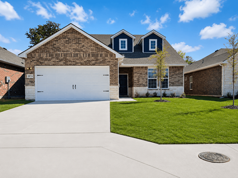 A house with a white garage door and a brick exterior.