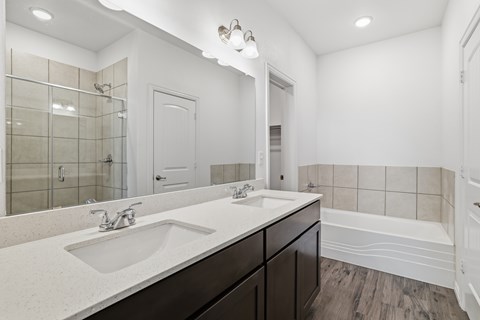 A bathroom with a white sink and a white tub.