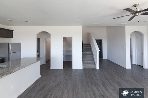 A spacious living room with a staircase leading to the upper floor.