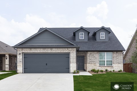 A two-story house with a garage and a driveway.