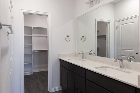 A bathroom with a white sink and a white mirror.