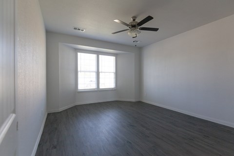 A room with a ceiling fan and a window.