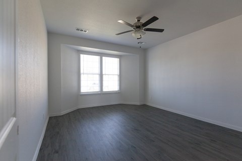 A room with a ceiling fan and a window.