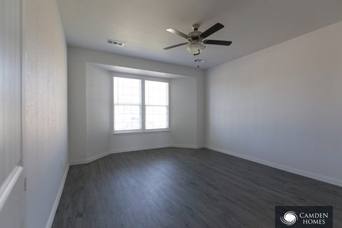 A room with a ceiling fan and a window.