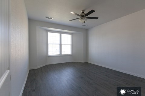 A room with a ceiling fan and a window.