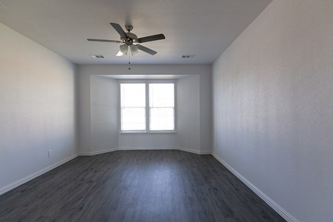 A room with a ceiling fan and a window.