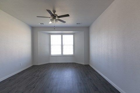 A room with a ceiling fan and a window.