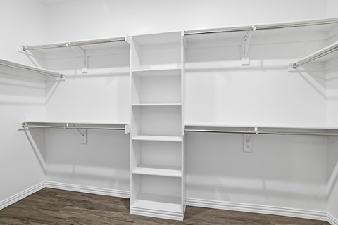 A white empty walk-in closet with shelves and a ladder.