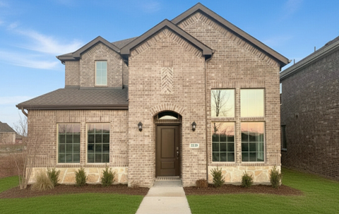 A brick house with a brown door and windows.
