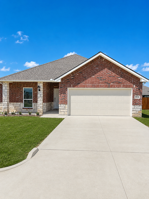 A brick house with a garage door and a window.