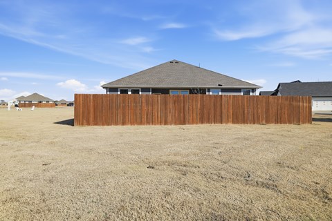 A house with a brown fence in the foreground.