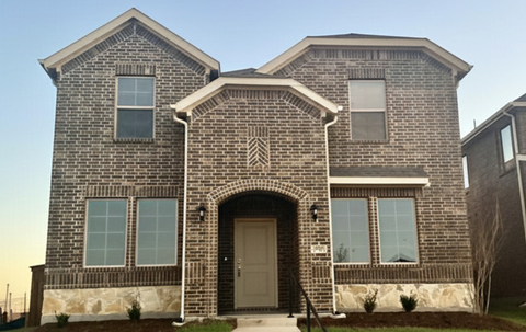A brick house with a front door and windows.