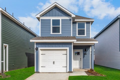 A two-story house with a garage door and a white door.