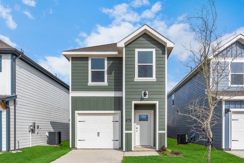 A two-story house with a garage and a white door.