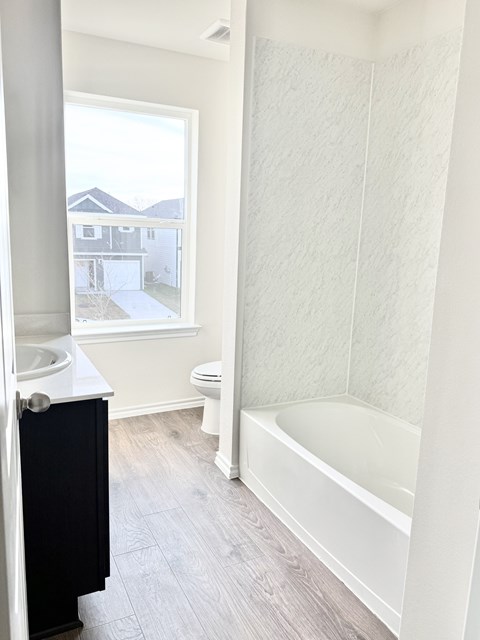 A bathroom with a toilet, sink, and bathtub.