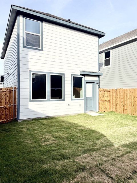 A house with a grey siding and a blue door.