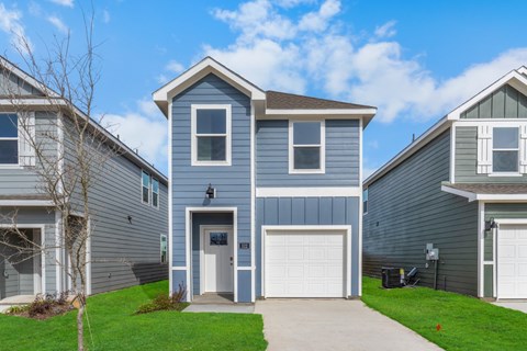 A blue house with a white garage door in front.