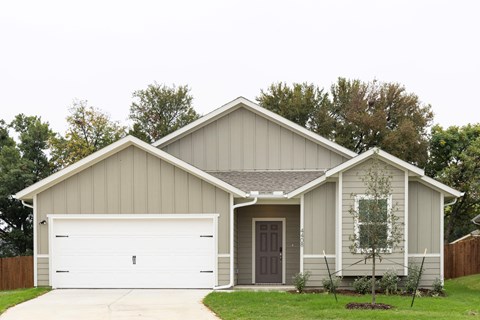 A house with a grey roof and a brown door.