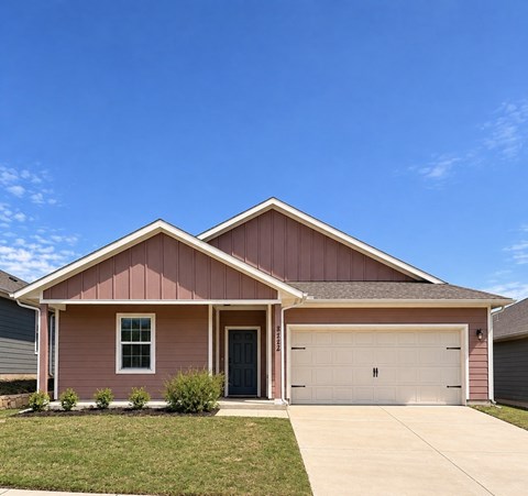 A house with a pink facade and a grey roof.