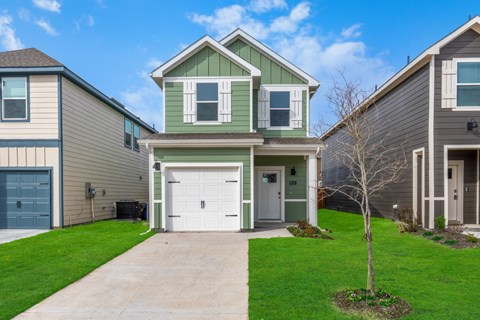 A house with a green roof and a white garage door.