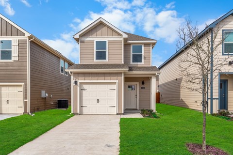 A two-story house with a garage and a driveway.