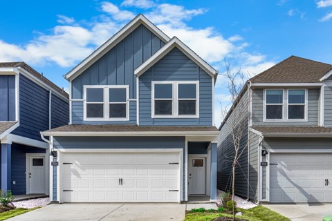 A blue house with a white garage door in front.