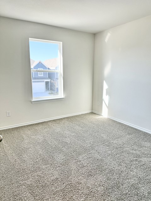 A room with a window showing a house outside.