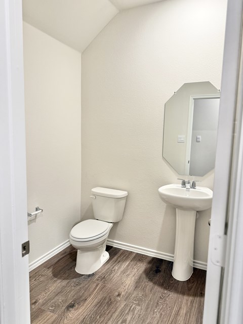A white toilet and sink in a small bathroom.